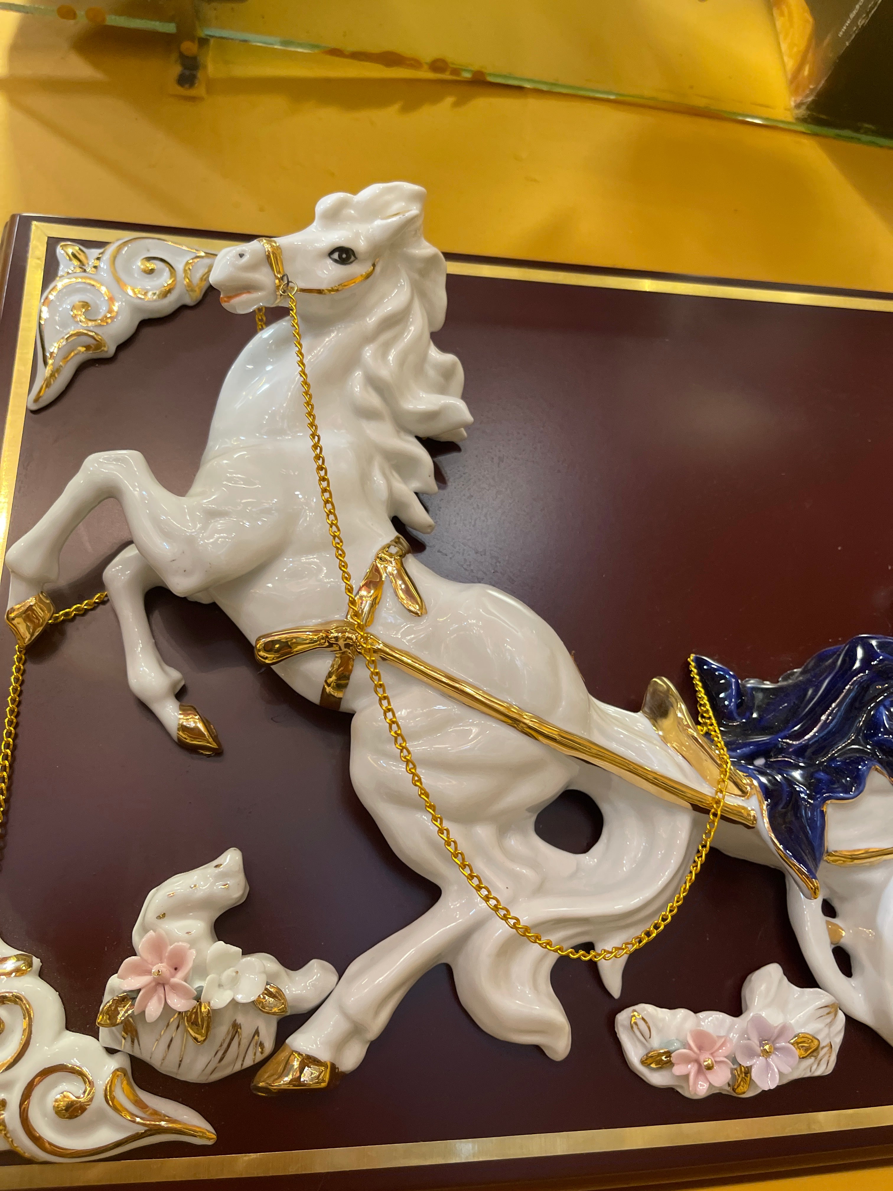 Lady in blue riding horse carriage in ceramic