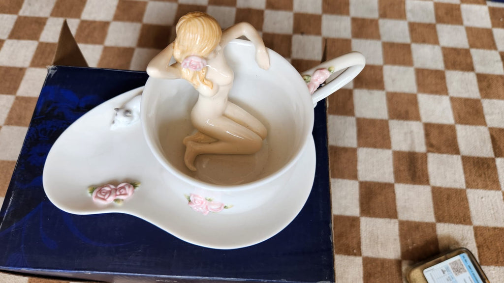 Cup and saucer with a nude lady in the cup