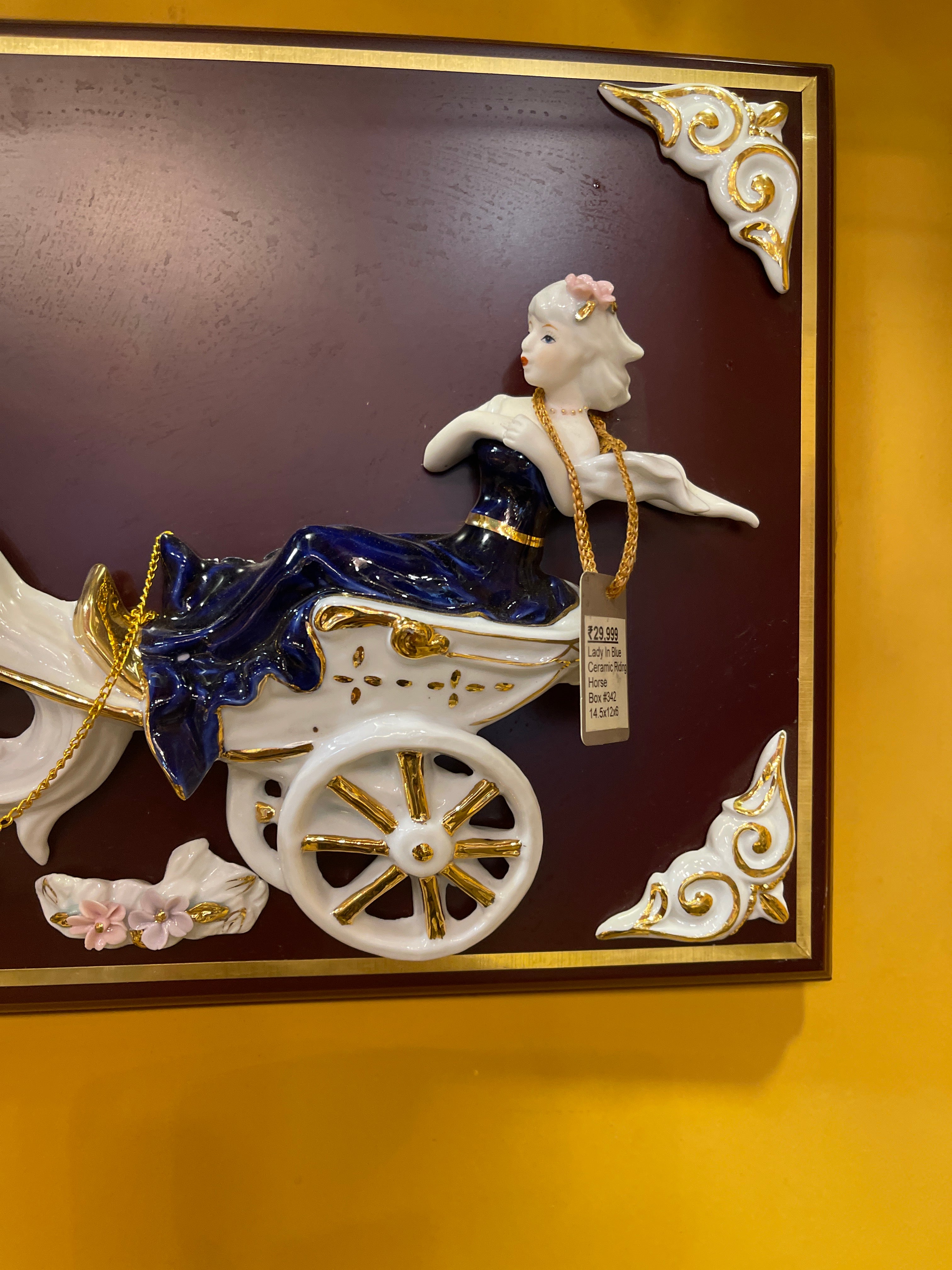 Lady in blue riding horse carriage in ceramic