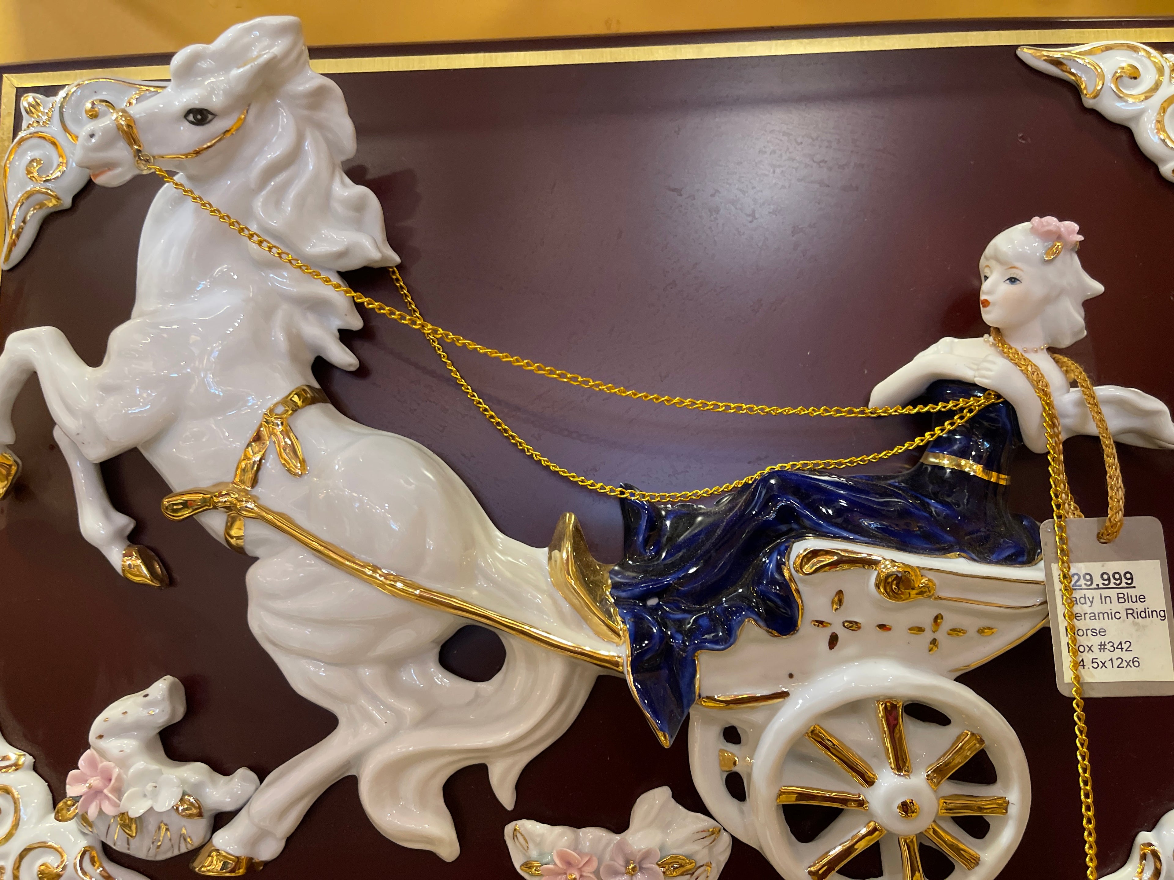 Lady in blue riding horse carriage in ceramic