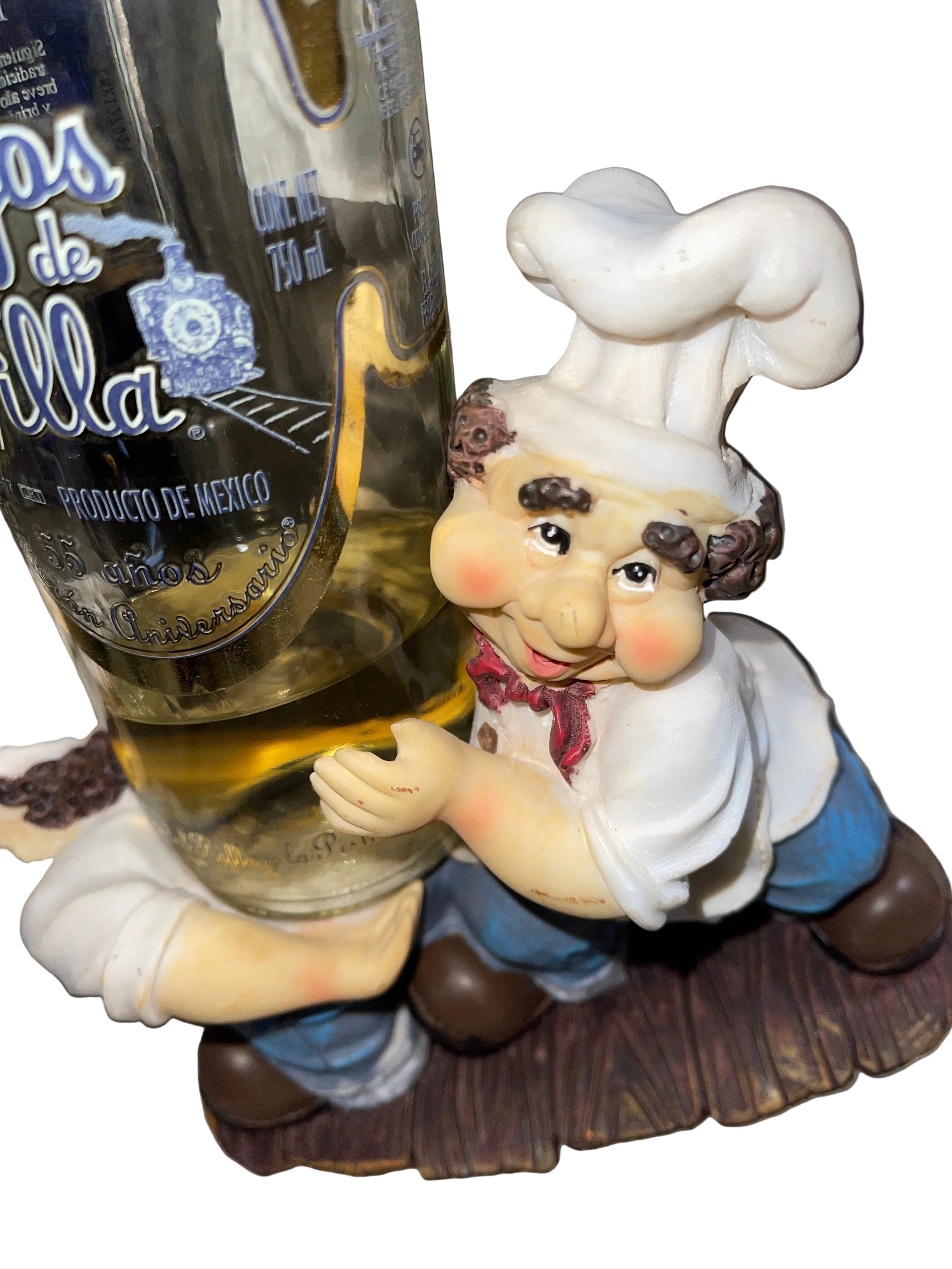 Figurine of a chef on top of a bottle with a label